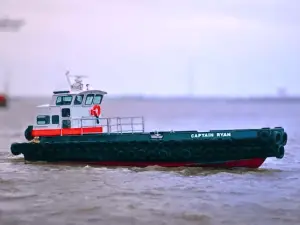 A small utility boat named "CAPTAIN RYAN" floats on calm water, with tires attached along its sides as bumpers.